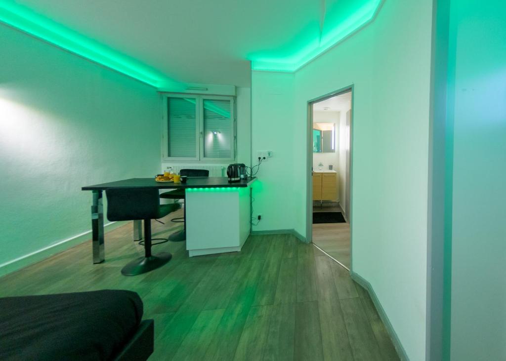 pokój z biurkiem i kuchnią z niebieskim oświetleniem w obiekcie Appart'Hôtel de la Gare - Cocooning w mieście Montbéliard