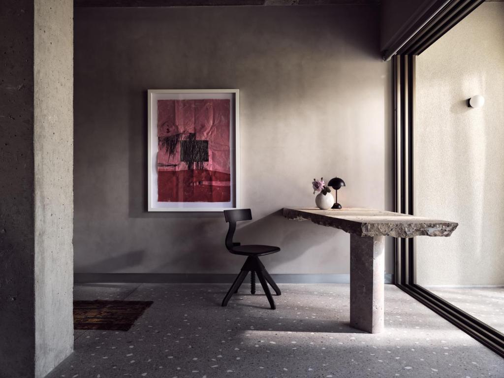 a table and a chair in a room with a picture at Ekies All Senses Resort, a Member of Design Hotels in Vourvourou