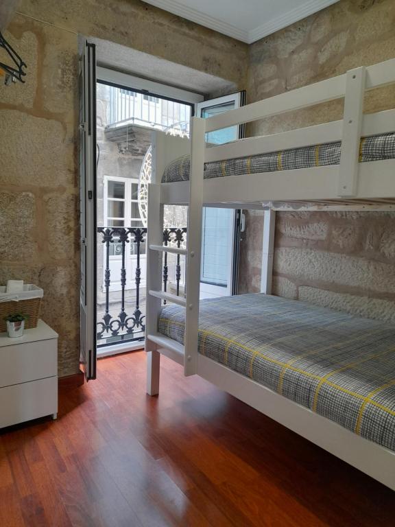 una camera con 2 letti a castello e un balcone di La Guinda Real a Vigo