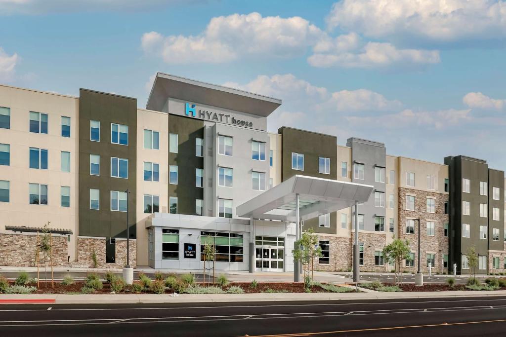 Hyatt House Davis في ديفيس: مبنى كبير مع منزل على جانب شارع