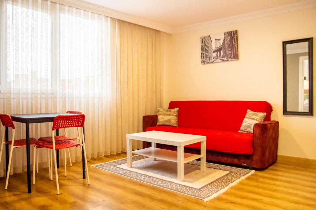een woonkamer met een rode bank en een tafel bij Colorful and Central Flat near Kulturpark Izmir in Izmir