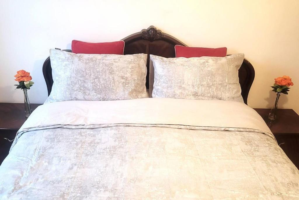 a bed with white sheets and red pillows at Beautiful 1-Bed Apartment in London in London