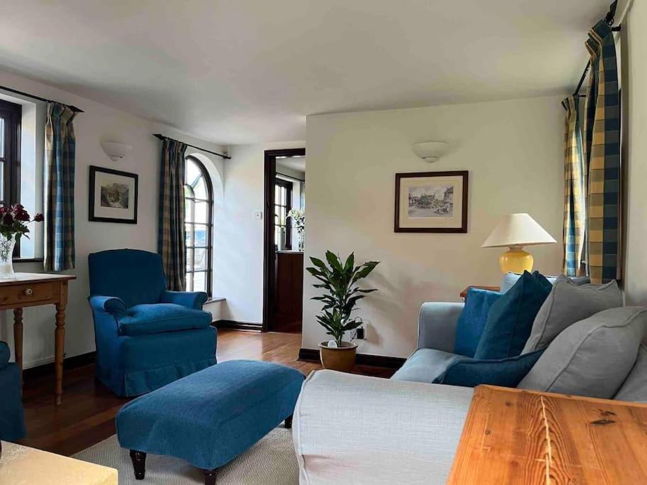 a living room with blue chairs and a table at Honeysuckle Cottage, Mickleton in Mickleton