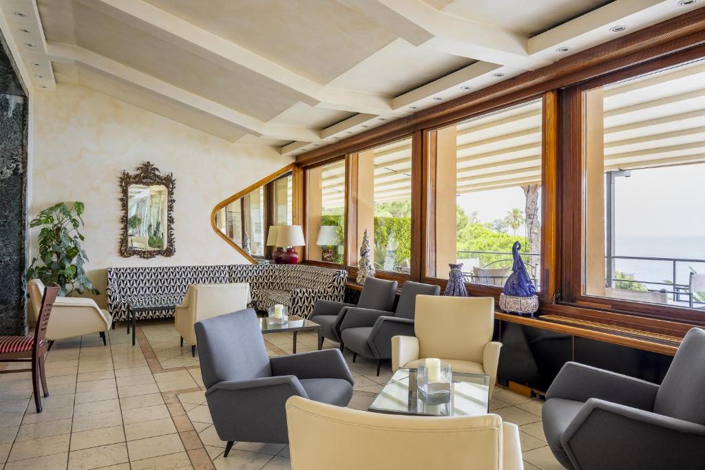a restaurant with chairs and tables and windows at Hotel Continental in Santa Margherita Ligure