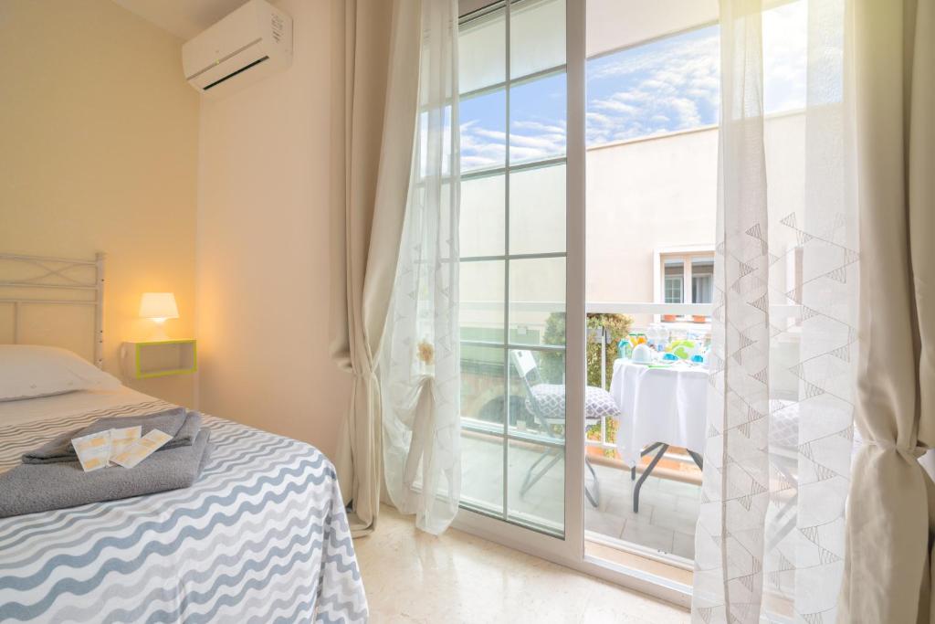 a bedroom with a bed and a balcony with a table at B&B Dei Musicisti in Polignano a Mare