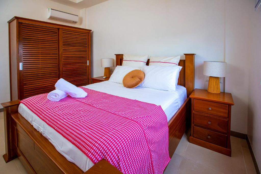 a bedroom with a large bed with a pink blanket at 3-Bedroom Apartment in Tema - Chez Akwasi in Tema