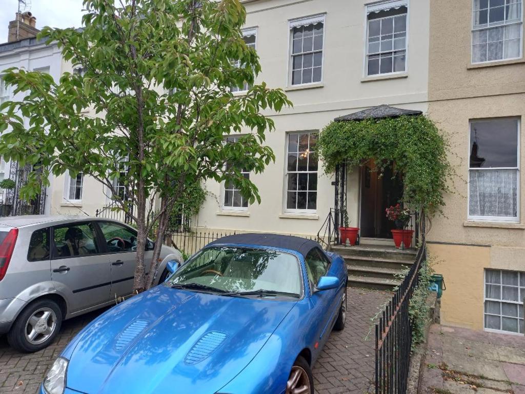 切爾滕納姆的住宿－Palsgrave Lodge，停在房子前面的蓝色汽车