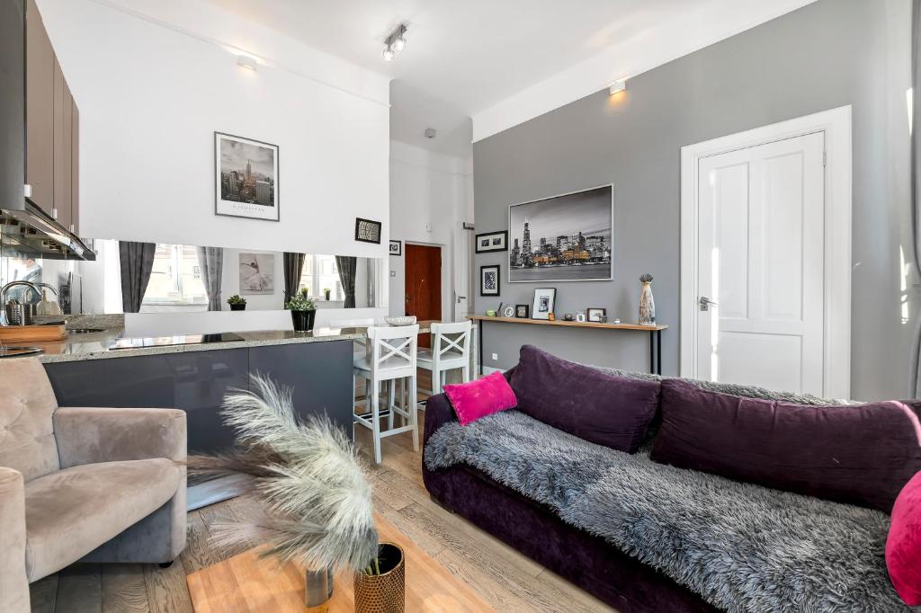 a living room with a couch and a kitchen at Lumina apartments on the market square near the Royal Castle in Warsaw