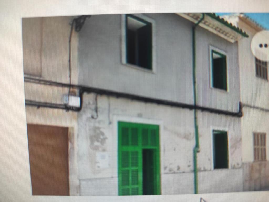 un edificio con una puerta verde a un lado en Casa de pueblo en Vilafranca, en Vilafranca de Bonany