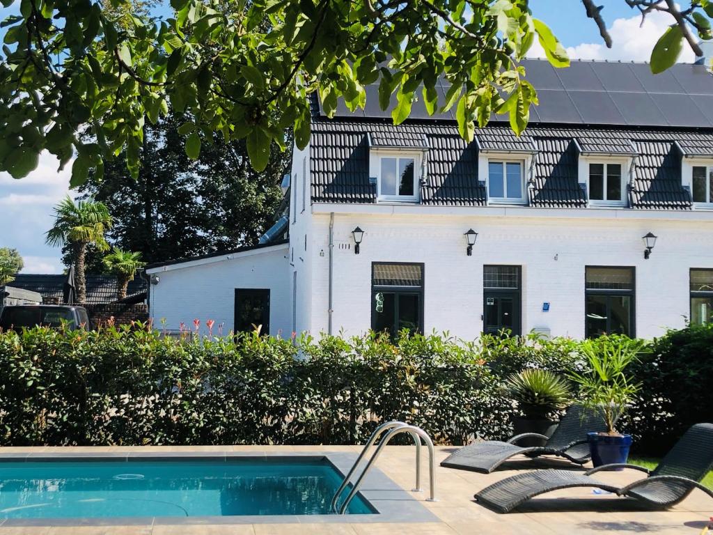 une maison avec une piscine en face d'un bâtiment dans l'établissement B &B Yuupke Maasbree Noord-Limburg Venlo Roermond, à Maasbree