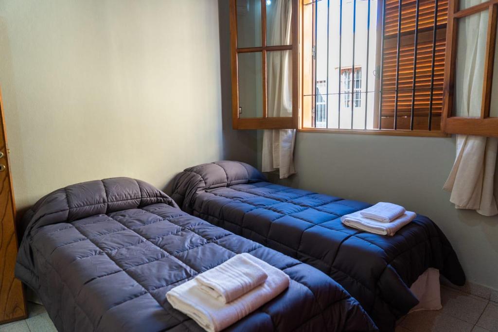 two twin beds in a room with a window at Casa Rosa in San Juan