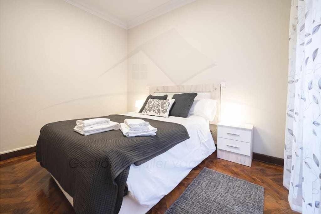 een slaapkamer met een groot bed en een zwart-witte deken bij Las Nieves Apartamento in Gijón