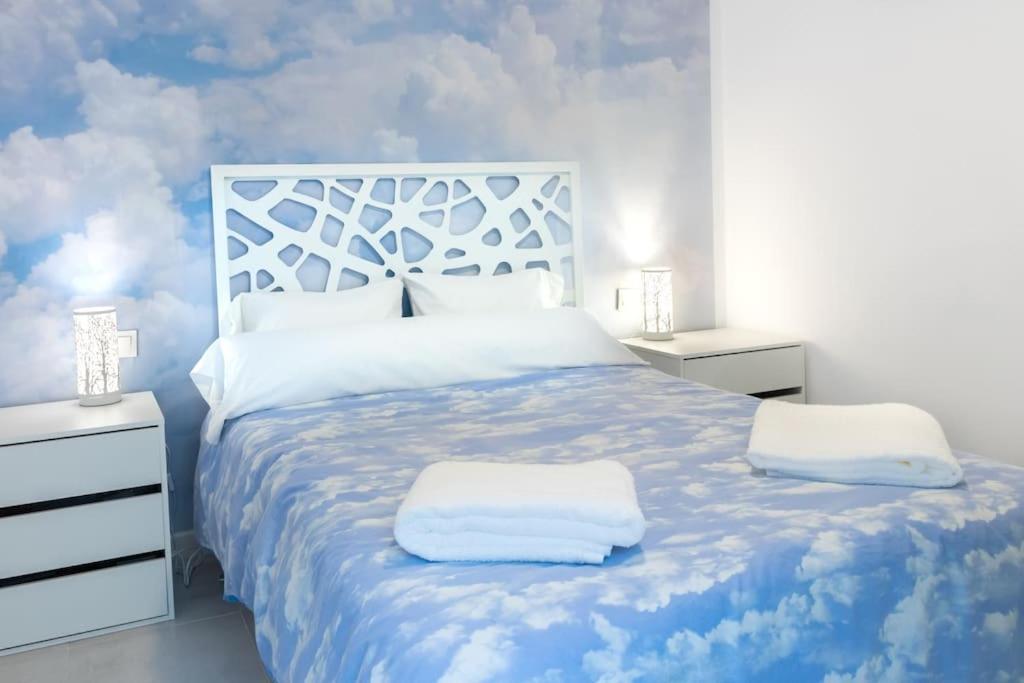 1 dormitorio con 1 cama azul y blanca y 2 almohadas en Apartamento completo a 5 minutos estación tren., en Córdoba