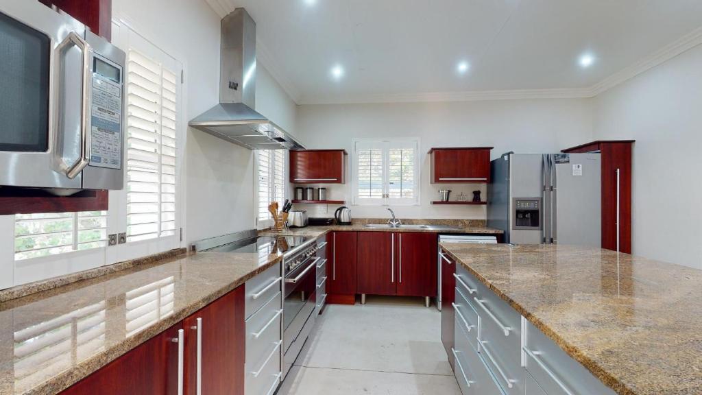 a kitchen with marble counter tops and stainless steel appliances at Khumbula at Caribbean Estates in Port Edward