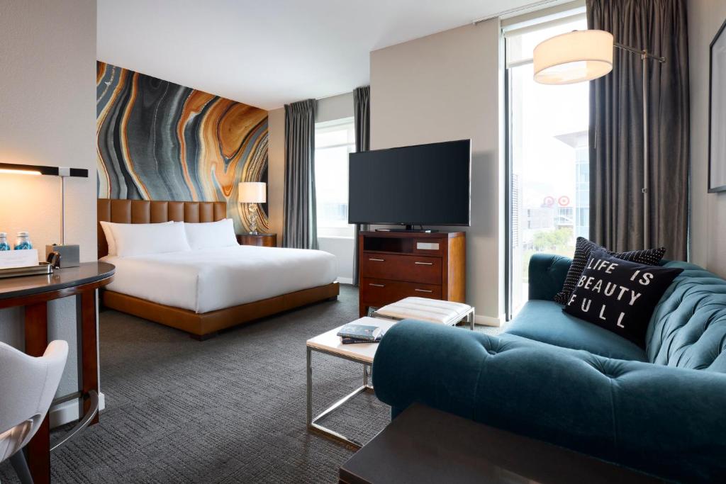 een hotelkamer met een bed, een bank en een tv bij Archer Hotel Falls Church in Fairfax