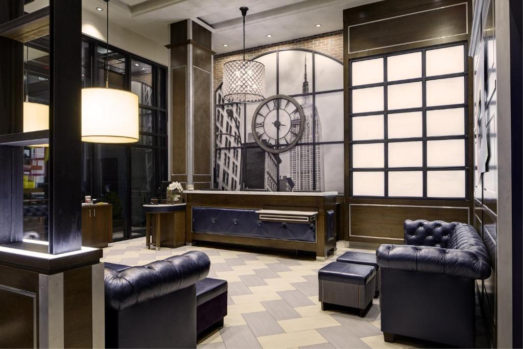 hol z krzesłami i zegarem na ścianie w obiekcie Archer Hotel New York w Nowym Jorku