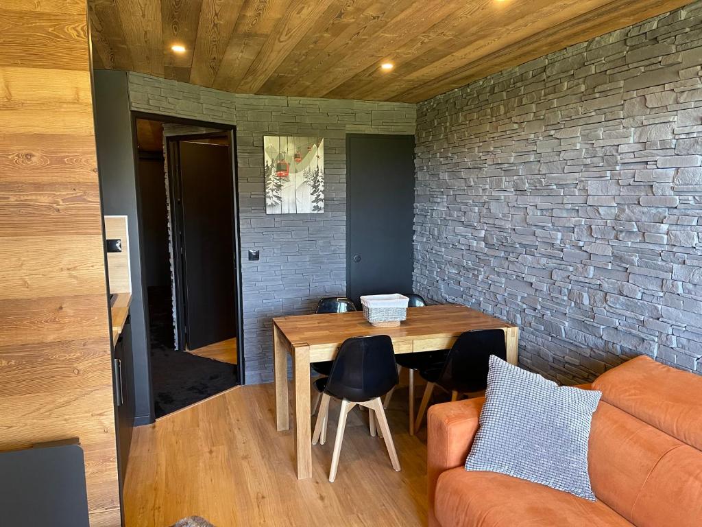 salon ze stołem i ceglaną ścianą w obiekcie Avoriaz Malinka w mieście Avoriaz