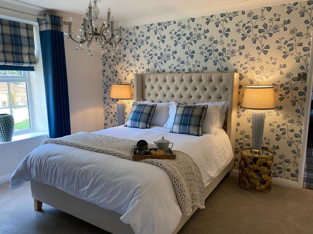 um quarto com uma cama grande e 2 candeeiros em The Farmhouse em Pontefract