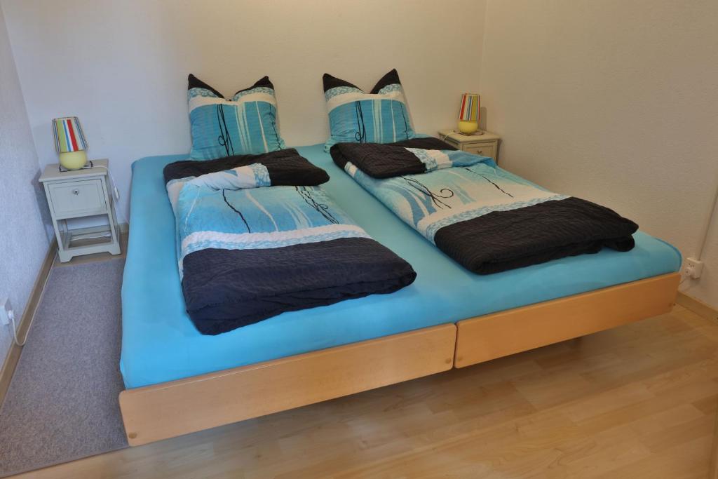 a bedroom with two beds with blue sheets at Hof Oberprehl in Murten