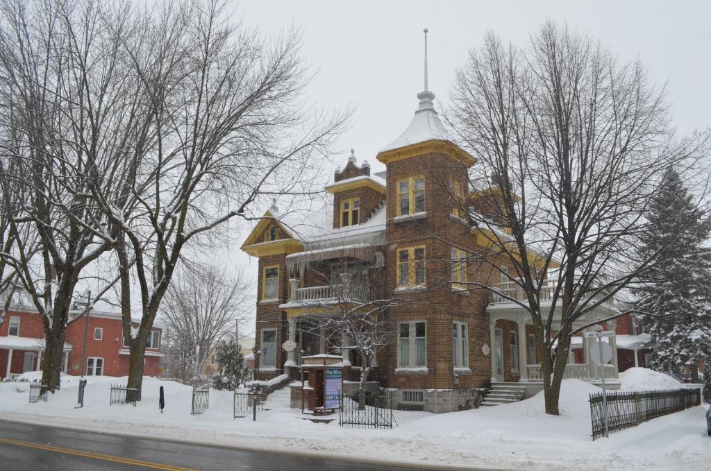 a large brick building with a tower in the snow at Le 100 St-Laurent in Louiseville