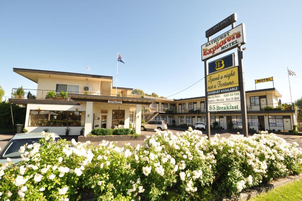 un cartello stradale di fronte a un edificio fiorito di Bathurst Explorers Motel a Bathurst