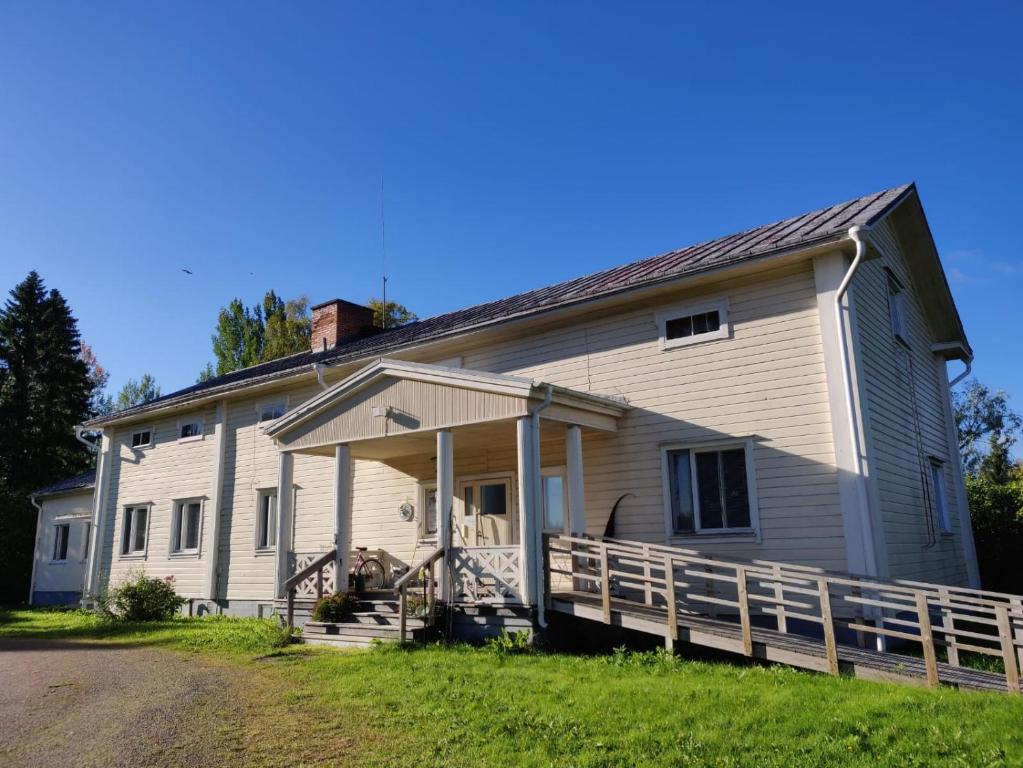 uma grande casa branca com um grande alpendre em Kattilakosken vanha Pappila em Kärsämäki