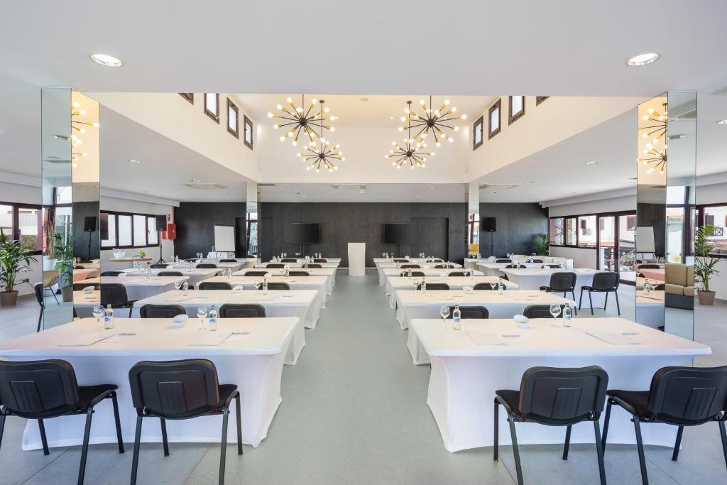 a large banquet hall with white tables and chairs at Occidental Roca Negra - Adults Only in Agaete