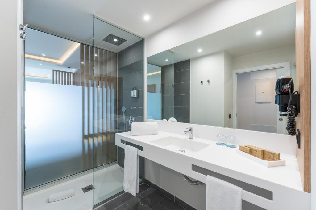 a bathroom with a sink and a large mirror at Occidental Roca Negra - Adults Only in Agaete