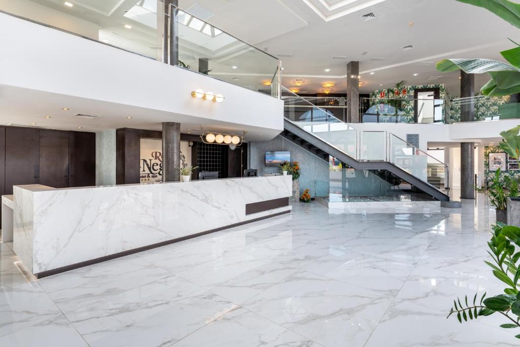 a lobby with a staircase and marble flooring at Occidental Roca Negra - Adults Only in Agaete