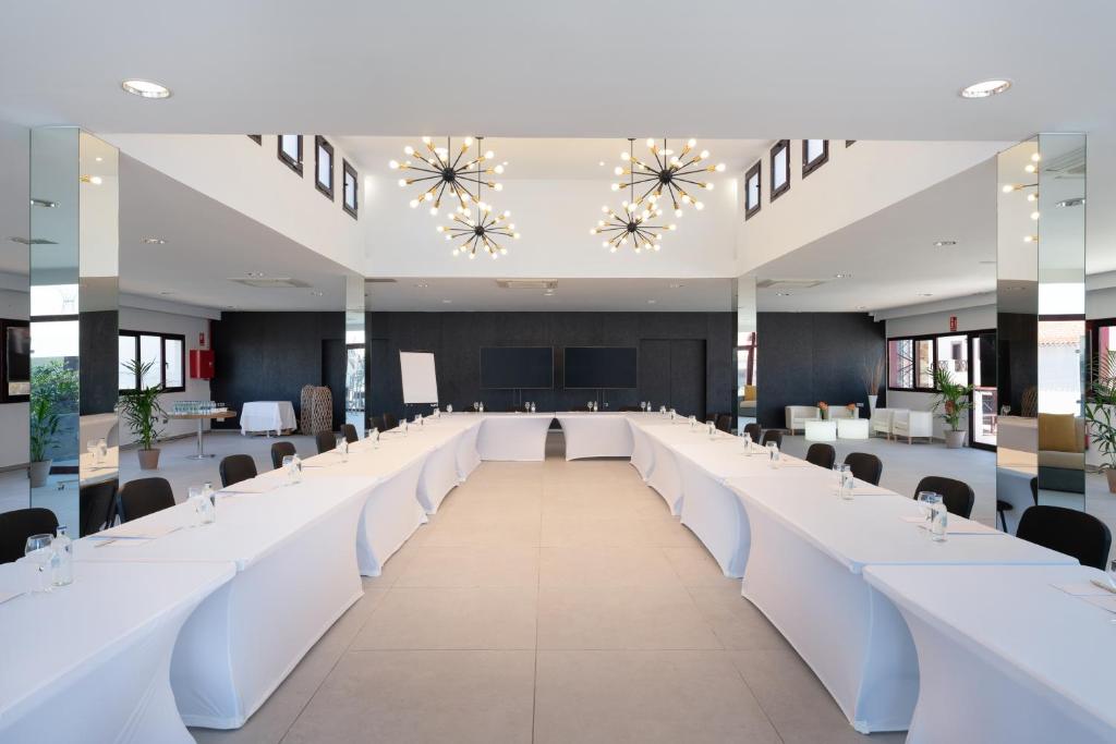 a large conference room with white tables and chairs at Occidental Roca Negra - Adults Only in Agaete