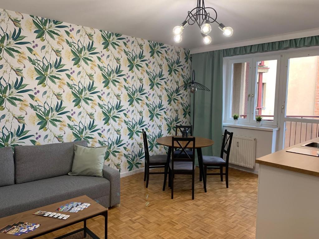 een woonkamer met een bank en een tafel met stoelen bij APARTAMENT GERSONA in Bydgoszcz