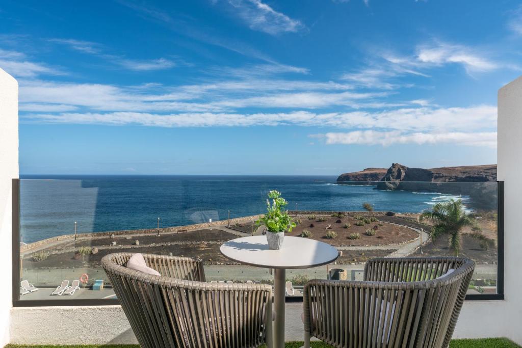 a table and two chairs with a view of the ocean at Occidental Roca Negra - Adults Only in Agaete