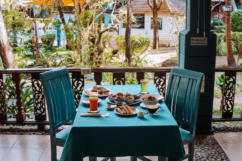 une table avec un chiffon de table bleu et de la nourriture dans l'établissement Baan Kiao, à Haad Yao