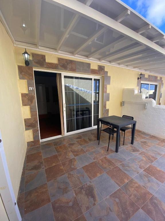 a patio with a black table and a window at Club JM Lanzarote in Tabayesco