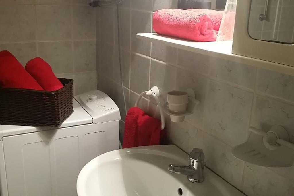 bagno con lavandino, servizi igienici e asciugamani rossi di AIRAM Apartment CENTER BUDAPEST a Budapest