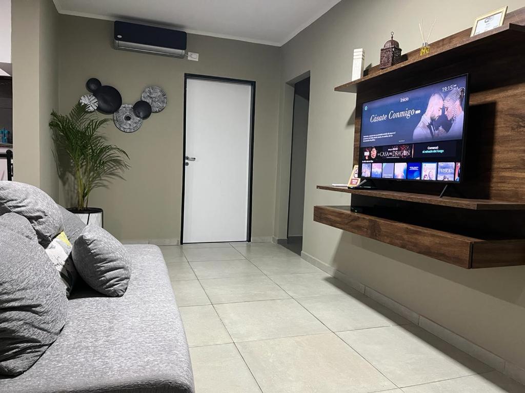 a living room with a couch and a flat screen tv at Avalon Apartments in Puerto Iguazú