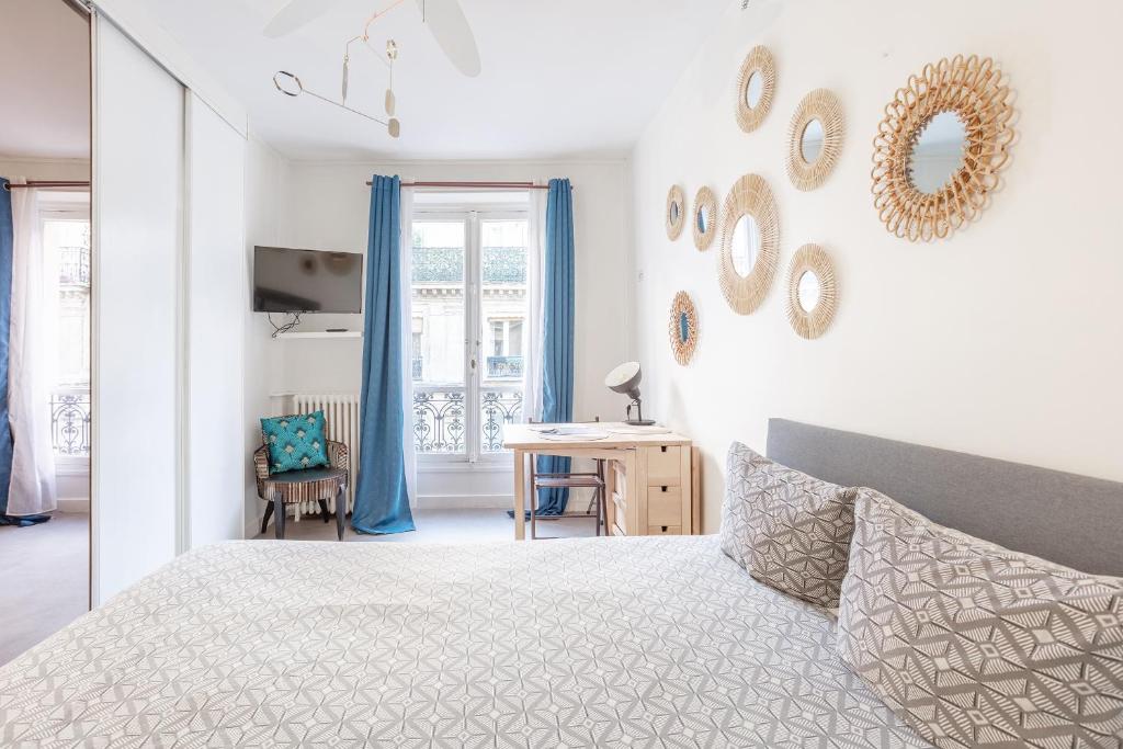 une chambre blanche avec un lit et un bureau dans l'établissement Opéra Cozy Flat, à Paris