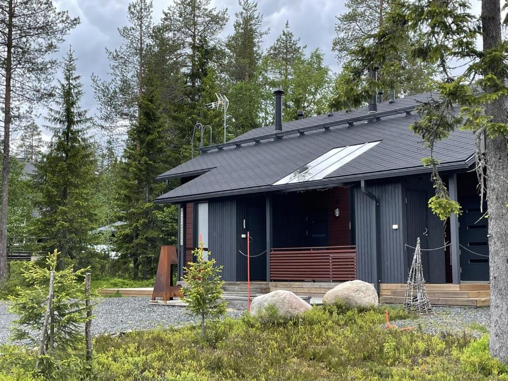 a house in the woods with rocks in front of it at Syötteenolo in Syöte