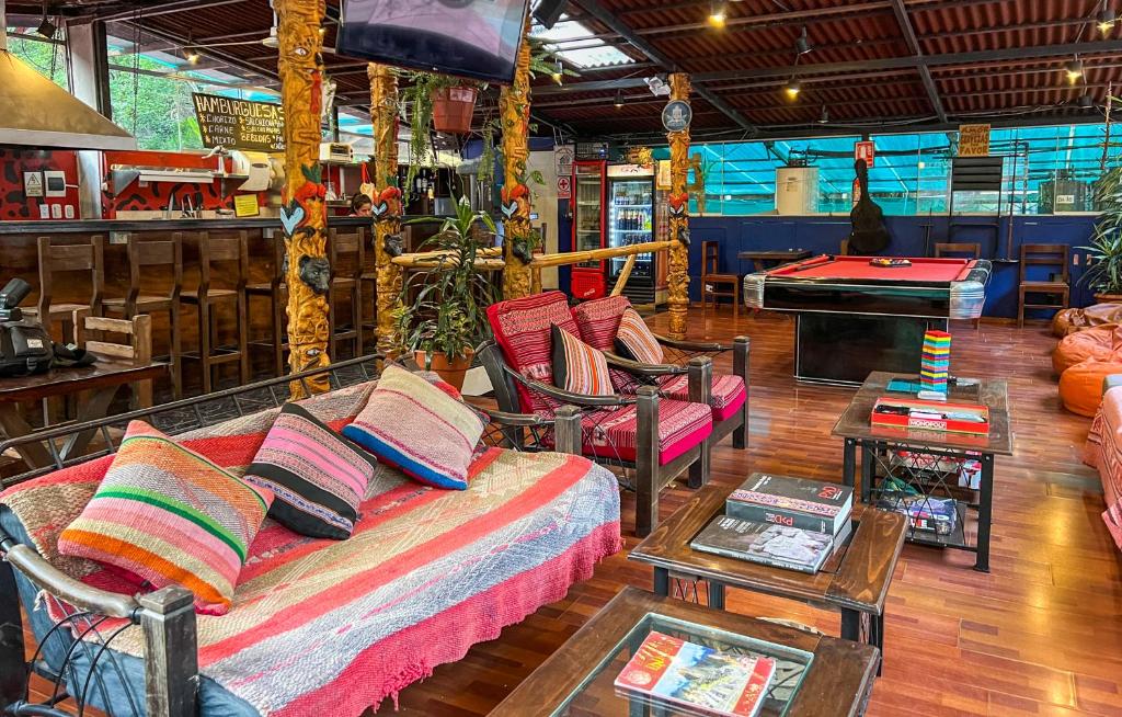 ein Wohnzimmer mit einem Sofa, Stühlen und einem Tisch in der Unterkunft Nativus Hostel Machu Picchu in Machu Picchu