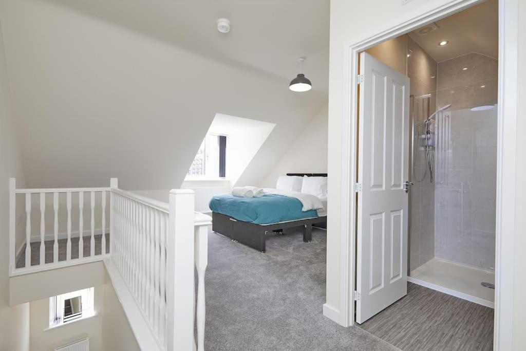 ein Schlafzimmer mit einem Bett und einer ebenerdigen Dusche in der Unterkunft Prime Location & Free Parking Stylish 3-Bed Home in Leicester