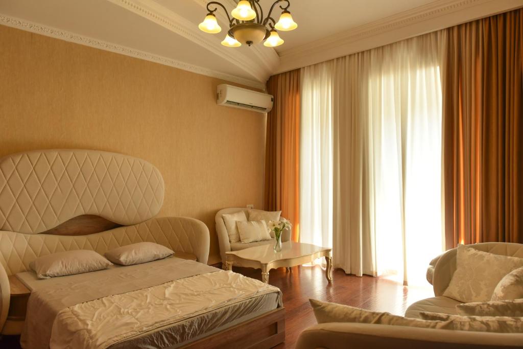 第比利斯Apartment Elizabeth in Old Tbilisi的一间卧室，有两张床、一张沙发和一把椅子