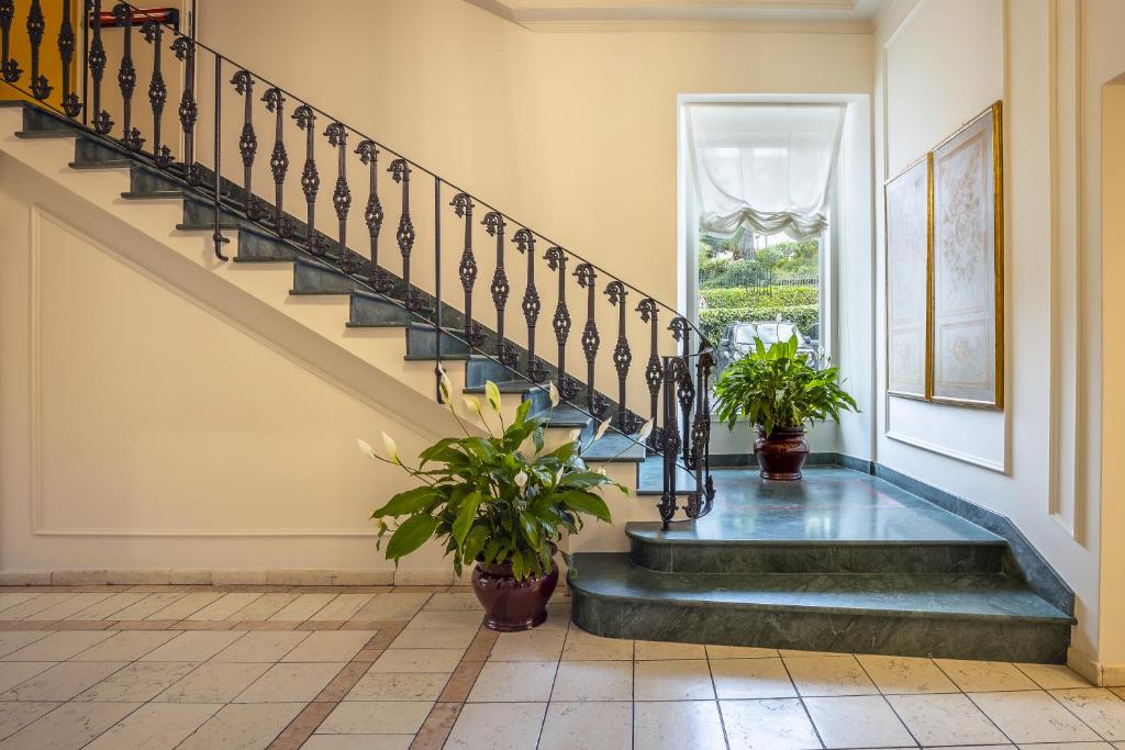a staircase in a home with two potted plants at Hotel Continental in Santa Margherita Ligure