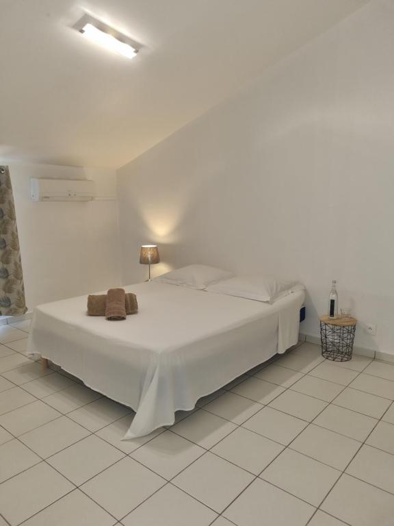 a white bedroom with a bed in a room at Ô Moulin de la canne à sucre in Mamoudzou