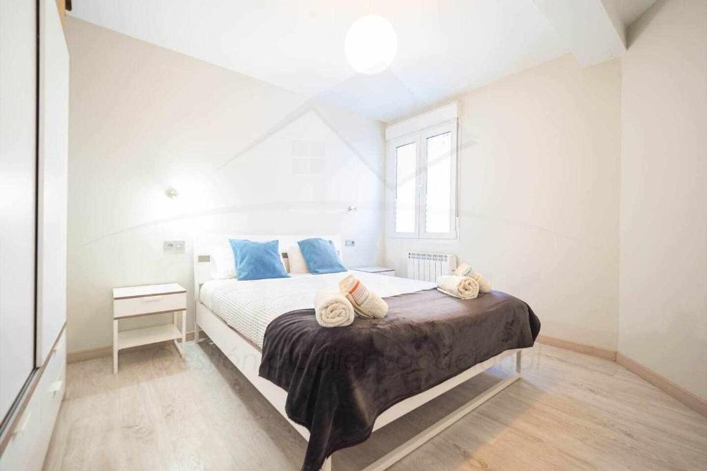 1 dormitorio con 1 cama con toallas en Luanco 11 Apartamento centro de Gijón, en Gijón