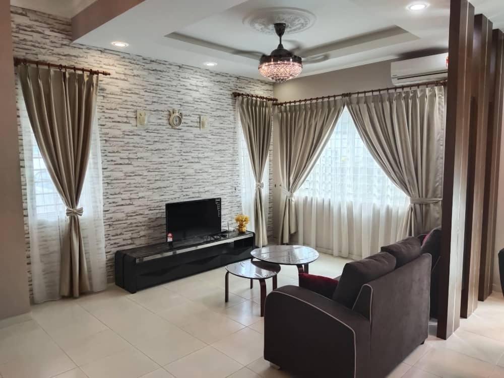 ein Wohnzimmer mit einem Sofa, einem Tisch und einem TV in der Unterkunft Ann_HomeStay in Sandakan