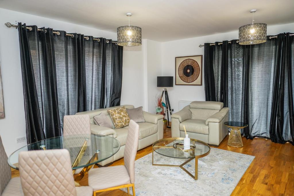 a living room with a couch and a table and chairs at DARTFORD LUXURY 2 BED APARTMENT in Kent