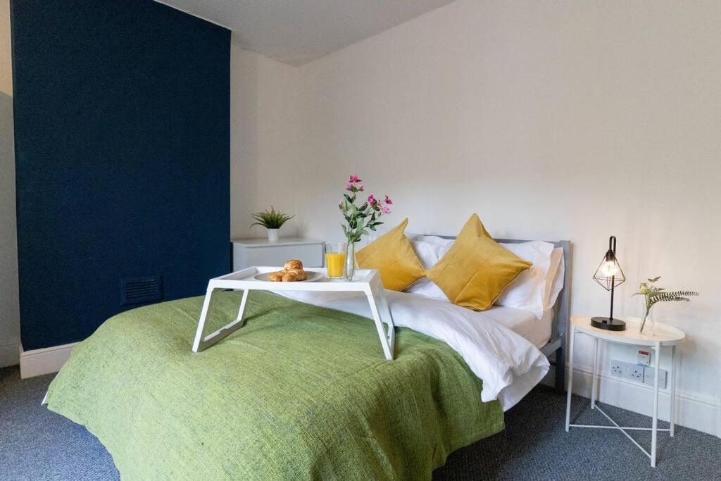 a bedroom with a bed with a table on it at Room for All Your 4-Bedroom Comfort Zone in Leicester