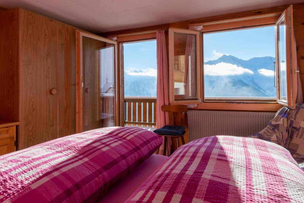 a bedroom with two beds and a view of the mountains at Chalet Weisshorn 4 in Bettmeralp