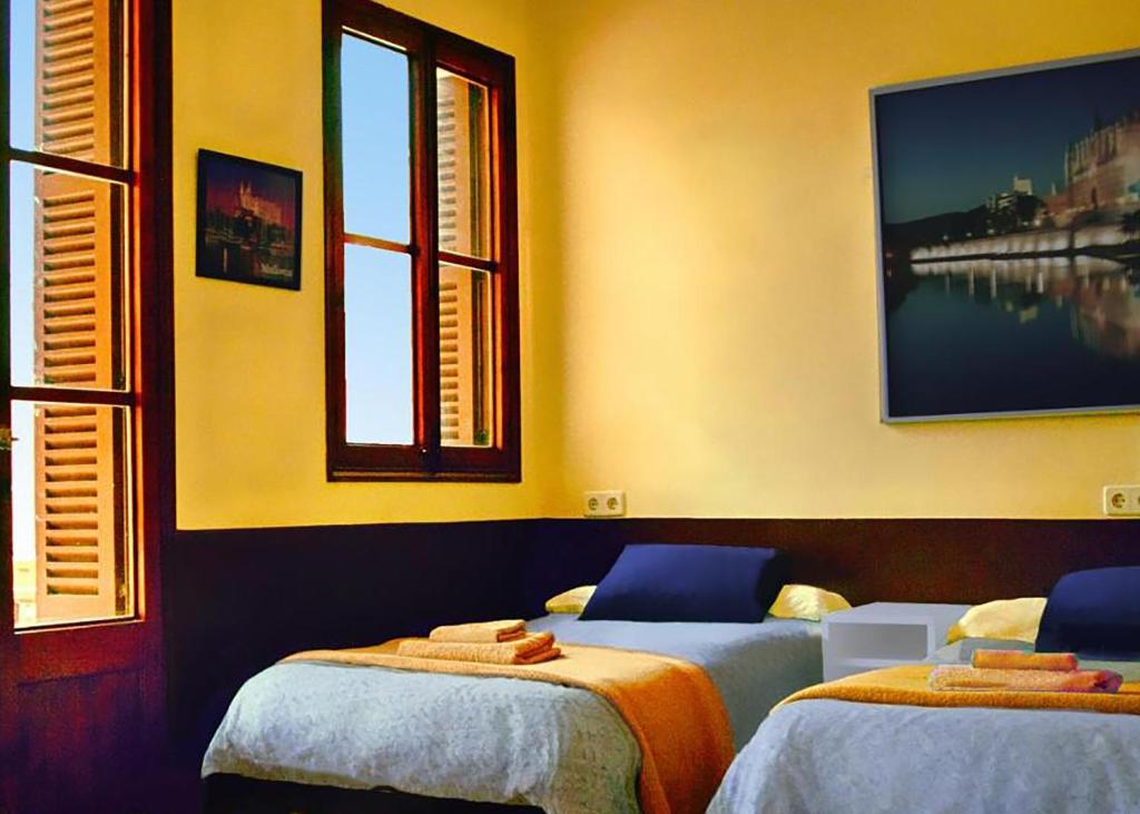 um quarto com 2 camas e uma janela em Hostal Atlanta em El Arenal