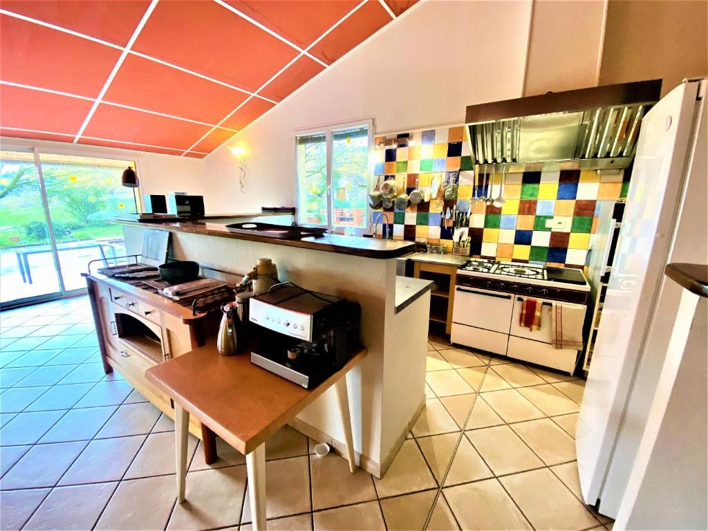 a kitchen with a stove and a counter top at CHAMBRES D&#39;HOTES 2 à 4p ou GITE DE GROUPE 15p, 7 ch, 6 sdb, parc et salle de réception in Villeneuve-de-Berg